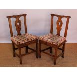 A set of four George III country oak dining chairs,