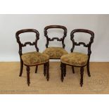 A set of four William IV carved mahogany dining chairs, with buckle backs and upholstered seats,