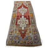 A Persian full pile wool runner, worked with two gulls against a red ground in pale colours,