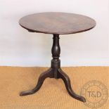 A George III oak occasional table, circular three plank top, on a turned column and tripod base,