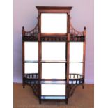 A late Victorian walnut hanging shelf, with mirror back and eight shelves,