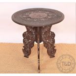 A carved Anglo-Indian occasional table, with folding base and circular top,