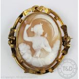 A carved shell cameo brooch depicting Goddess Artemis, within yellow metal elaborate scroll frame,