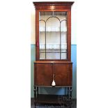 An Edwardian mahogany display cabinet, of slender proportions, with glazed door enclosing shelves,