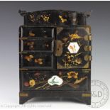 A Japanese lacquered kodansu, with an arrangement of six drawers and a cupboard door,