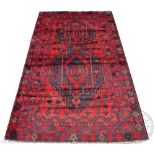A Baluch wool rug, worked with two gulls against a blue and red ground,