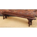 A pair of late 19th century and later stained pine long benches,
