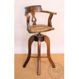 An early 20th century stained beeck childs swivel high chair, with caned seat,