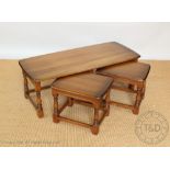 A nest of three Ercol dark light wood coffee tables, on turned legs,