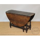 An 18th century oak gate leg table, on turned and block legs,
