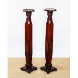 A pair of Edwardian inlaid mahogany jardiniere stands, formerly bed posts,