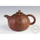 A Chinese Yixing teapot and cover, of pumpkin form and with foliage on relief, 10.