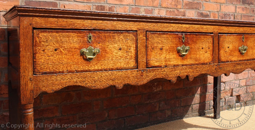 An 18th century Shropshire oak dresser base, with three drawers above a serpentine apron, - Image 2 of 4