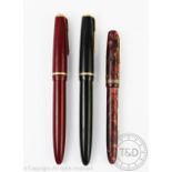 Two Parker Duofold fountain pens, each with a '14k' nib and engine turned banding to the exterior,