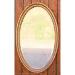 A late Victorian gilt wood and gesso oval wall mirror, with egg and dart moulded border,