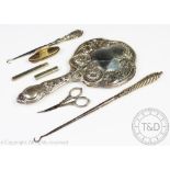 A selection of silver to include a profusely embossed Art Nouveau silver backed dressing table