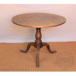 A George III oak occasional table, with circular three plank top, on turned column and tripod base,