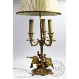 A late Victorian gilt metal table lamp, modelled with two birds, fruit and foliage,