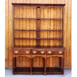 A George III style oak high back dresser, with moulded cornice and three plate shelves,