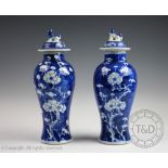 A pair of early 20th century Chinese porcelain blue and white prunus vases and covers,