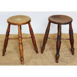 A pair of late 19th century beech stools, with circular seats, on turned legs,