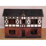 An early 20th century painted pine dolls house, modelled as a Tudor style manor, double fronted,