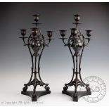 A pair of 19th century bronze four branch candelabra, with floral scroll detailing,