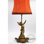 A Victorian gilt brass figural table lamp, modelled as a cherub standing upon a scroll base,