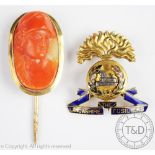 The Lancashire Fusiliers badge in yellow metal, unmarked, and a coral cameo stick pin,