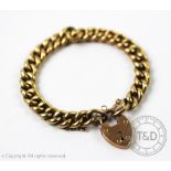 A yellow metal curb link bracelet with an attached padlock clasp stamped '9ct', gross weight 16.