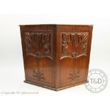 An Arts and Crafts carved walnut waste paper bin, decorated with foliate motifs,
