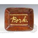 A late 19th / early 20th century slipware 'Pork' dish, in the manner of Buckley pottery,