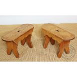 A pair of oval pine milking stools,56cm wide,