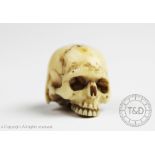 A 19th century Japanese carved ivory momento mori model of a skull,