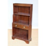 A Regency style mahogany waterfall bookcase, with drawer, on bracket feet,
