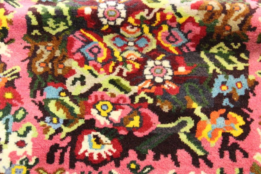 A Persian full pile wool rug, worked with a central floral spray, - Bild 3 aus 4