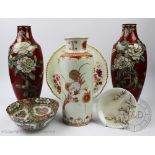 A pair of Japanese cloisonne vases, each decorated with white peony's against a red ground,