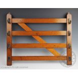 An Edwardian oak novelty coat rack modelled as a country gate, set with eight brass hooks,