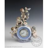 A Lladro mantel clock designed as a central globe inset with a clock surmounted by four putti and