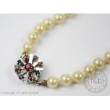 A cultured pearl necklace with gem set white metal clasp,