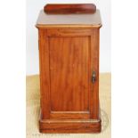 A Victorian walnut bedside pot cupboard, with panelled door, on plinth base,