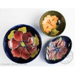 Three Moorcroft dishes, in Clematis, Anemone and Hibiscus pattern against blue and green grounds,