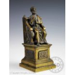 A 20th century cast brass Grand Tour style model of an Emperor, designed seated and holding a key,