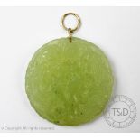 A carved jade coloured pendant,