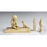 A late 19th/early 20th century European carved ivory group depicting a young boy eating with a dog