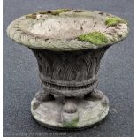 A reconstituted stone circular garden planter with basket design, on a square claw base,