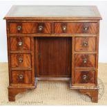 A George III style mahogany knee hole desk, with an arrangement of eight drawers, on bracket feet,