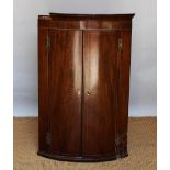 A George III mahogany bow front corner cabinet,