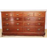 A late Victorian walnut chest, of long proportions, with four short and six long drawers,