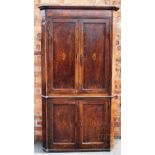 A George III inlaid oak free standing corner cabinet, with two inlaid doors enclosing shelves,